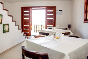 a dining room with two tables and a staircase at Pousada Nossa Ilha in Itamaracá