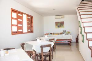 a dining room with two tables and a window at Pousada Nossa Ilha in Itamaracá