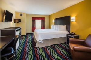 een hotelkamer met een bed en een bank bij Days Inn & Suites by Wyndham Augusta Near Fort Eisenhower in Augusta