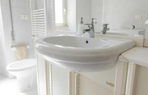 a white bathroom with a sink and a toilet at Michelangelo Apartment in Civitavecchia +27 photos