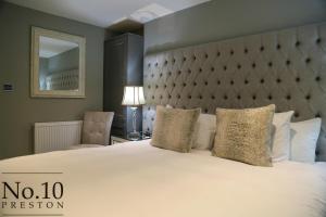 een slaapkamer met een groot wit bed met een groot hoofdeinde bij No.10 Preston in Preston
