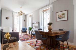 a living room with a table and chairs at Alfama Sophisticate Flat With Balconies 2Bedrs 2Baths & AC in 19th Century Building Historic Center in Lisbon