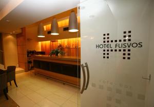 un cartel de fluxos de hotel en la puerta de un restaurante en Hotel Flisvos en Kalamata