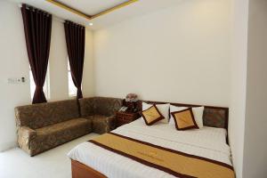 a bedroom with a bed and a couch at Satraco Royal Hotel in Soc Trang