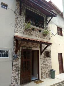 a building with a gate and potted plants on it at LINDO CHALÉ NO CENTRO DE GUARAMIRANGA in Guaramiranga