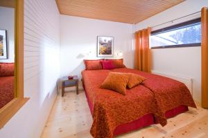 a bedroom with a bed with a red blanket and a window at Holiday Club Pyhä HolySuites in Pyhätunturi