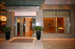 a hotel entrance with two potted plants in a lobby at Hotel Flisvos in Kalamata