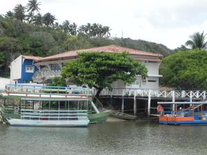 two boats docked next to a house on a river at POUSADA Dunas de Marape - Alagoas in Jequia da Praia +18 photos