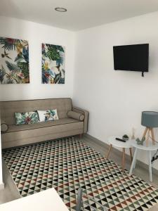 a living room with a couch and a tv at Avenida in Praia de Mira
