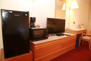 a hotel room with a microwave and a coffee maker on a desk at Widus Inn in Swift Current