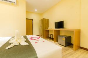 a room with a bed and a desk with a television at My Living Place Nathon in Nathon