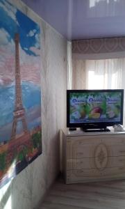 a tv sitting on a dresser in a room at Rooms in Apartment on Tbilisskiy bulvar 11 in Yekaterinburg