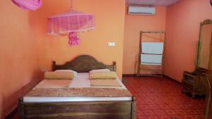 une chambre avec un lit avec une tête de lit en bois dans l'établissement Blue Sky Guest House Dambulla, à Dambulla
