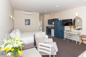 Habitación de hotel con cama y comedor en Te Mata Lodge en Havelock North