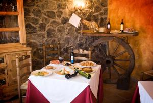 una mesa con platos de comida y botellas de vino en Complejo Peñafiel, en Zarza la Mayor