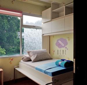 a bed in a room with a large window at Bene Room at Jarrdin Cihampelas in Bandung