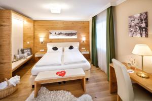a hotel room with a bed and a desk and a room at Familienhotel Hinteregger in Katschberghöhe