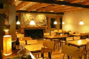 a restaurant with wooden tables and chairs and a fireplace at Ruca Pehuen Eco-Lodge De Montaña in Caviahue