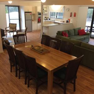 a dining room and living room with a wooden table and chairs at Echidna on Bruny in Barnes Bay