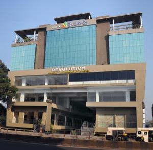 un edificio con un signo de aevolutions encima en Hotel 3 Leaves, en Kolhapur