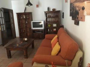 uma sala de estar com um sofá e uma televisão em Casa Daniela em Arrecife