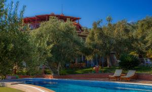 a swimming pool in front of a house at Aeneas Hotel in Altınoluk