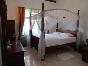 a bedroom with a bed with a canopy at Tea Hills Bungalow in Hatton