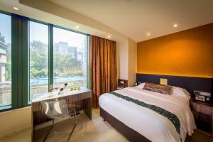 a bedroom with a bed and a sink and a window at Harbour Bay Hotel in Hong Kong