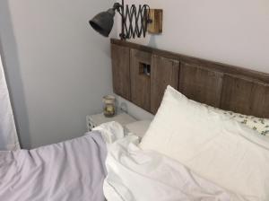 1 cama con sábanas blancas y cabecero de madera en Appartamento73, en Cignone