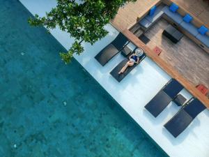 an overhead view of a person sitting on a chair next to a pool at U Pattaya in Na Jomtien