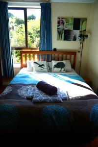 a bed with two pillows and a cat on it at Little Paradise & Petting Farm in Greymouth