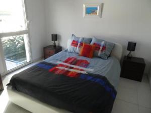 ein Schlafzimmer mit einem großen Bett mit bunten Kissen in der Unterkunft Modern one bedroomed apartment just off the Cannes Seafront with a terrace and pool access 1753 in Cannes