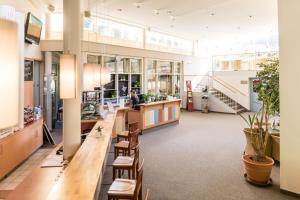 a large lobby with a long counter and chairs at JUFA Hotel Veitsch in Veitsch