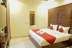 a bedroom with a large bed with a red blanket at Hotel Chanakya inn in New Delhi