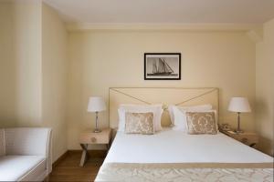 a bedroom with a bed with two lamps and a couch at Grand Hotel Portovenere in Portovenere