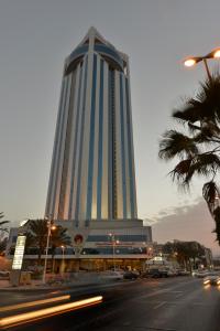 a tall blue building with a street in front of it at Awaliv International Hotel in Taif