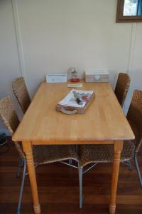a wooden table with chairs and a box on it at Little Paradise & Petting Farm in Greymouth