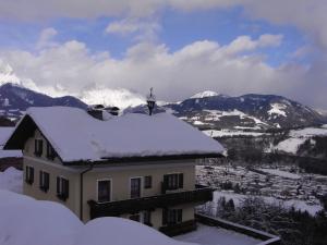 ビショフスホーフェンにあるHaus Kleinschöneggの山々を背景に雪に覆われた家