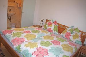 ビショフスホーフェンにあるHaus Kleinschöneggの花柄のシーツと枕付きのベッド