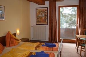 a bedroom with a bed, chair and a window at Chalet Kammleitn in Hermagor