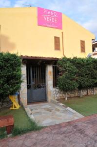カステルダッチャにあるPiano Verde Casa Vacanzeのピアノのしだれを読む看板を持つ黄色い建物