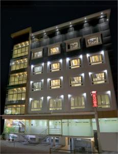 a tall building with lights on it at night at Kenz Residency in Cochin