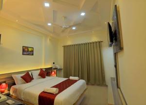 a bedroom with a large bed and a television at Kenz Residency in Cochin
