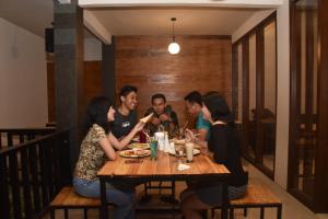 a group of people sitting around a wooden table at Hotel Orizatha in Mataram