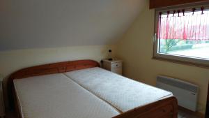 a small bedroom with a bed with a window at Haus Spitzenblick in Friedrichskoog