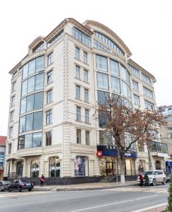 a large white building on the corner of a street at Central City Hotel Makhachkala in Makhachkala