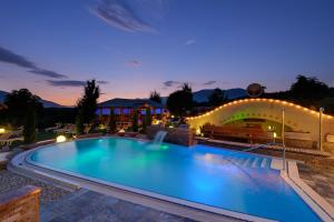 a large swimming pool in a resort at night at Hotel Scherer in Valdaora