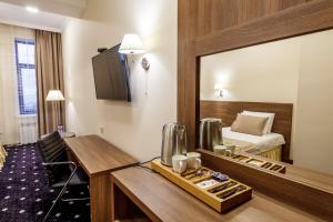 マハチカラにあるCentral City Hotel Makhachkalaのデスクとベッドが備わるホテルルームです。