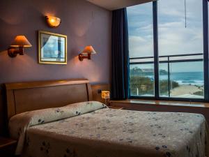 una camera con un letto e una grande finestra di Hotel Soraya a Suances