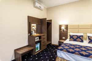 a hotel room with a bed and a tv at Central City Hotel Makhachkala in Makhachkala